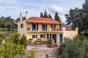 a yellow house with a red roof at Ilios Country house in Arillas