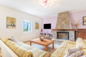 a living room with two couches and a fireplace at Ilios Country house in Arillas