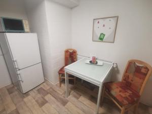 a kitchen with a white table and a refrigerator at Günstige, moderne Zimmer im Wanderparadies in Wernigerode