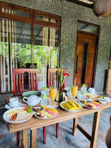 a wooden table with plates of food on it at La Casa Bella in Ella