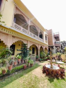 a courtyard of a building with potted plants and a fountain at The Kunadi Heritage by Boho Stays in Jaipur