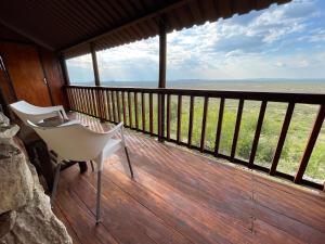 a porch with a chair and a view of the ocean at Aloegrove Safari Lodge in Otjiwarongo