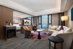 - un salon avec un canapé et une télévision dans l'établissement Hampton by Hilton Guangzhou Luoxi, à Canton