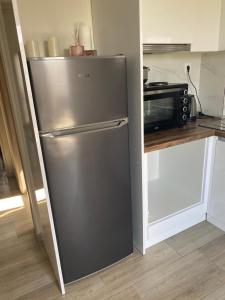 a stainless steel refrigerator in a kitchen with a microwave at Anastasia Apartment in Kalivia Poligirou