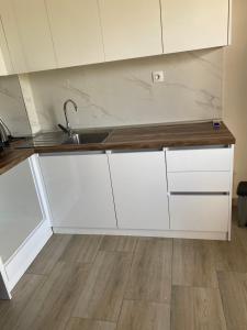 a kitchen with white cabinets and a sink at Anastasia Apartment in Kalivia Poligirou