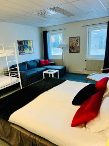 a bedroom with a large bed and a blue couch at Route 154, 15 min till Ullared in Älvsered