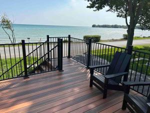 Eine Bank auf einer Terrasse mit Blick auf das Meer in der Unterkunft Elite Upper Deck Suites l Lake front with hot tub in Cayuga