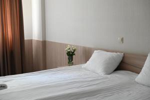 - une chambre avec un lit et un vase de fleurs dans l'établissement 612КМ, à Stry