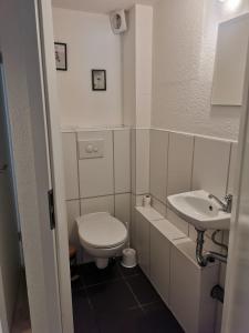 a small bathroom with a toilet and a sink at Günstige, moderne Zimmer im Wanderparadies in Wernigerode