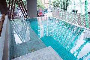 a swimming pool with a blue tiled floor and a swimming pool at AL Define Condo in Bangkok