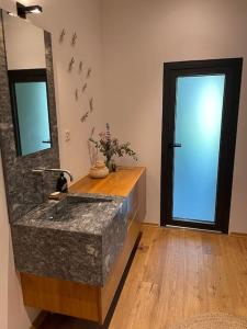 a bathroom with a marble sink and a mirror at Maison de rêve avec piscine à 5 minutes du lac. in Portalban- Dessous