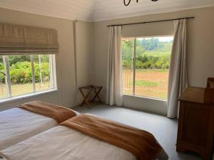 a bedroom with a bed and a large window at Gartmore Guest Farm in Howick