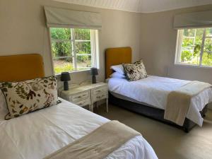 1 Schlafzimmer mit 2 Betten und 2 Fenstern in der Unterkunft Gartmore Guest Farm in Howick