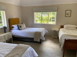 1 Schlafzimmer mit 2 Betten und einem Fenster in der Unterkunft Gartmore Guest Farm in Howick