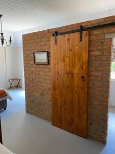 eine Ziegelwand mit einer Holztür in einem Zimmer in der Unterkunft Gartmore Guest Farm in Howick