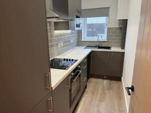 a kitchen with a sink and a stove top oven at Barassie, Troon in Troon