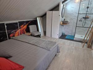 a bedroom with a bed and a chair in a room at Les Jardins de Nicole in La Plaine des Cafres