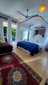 una camera con letto a baldacchino e tappeto rosso di Ulah Properties a Mombasa