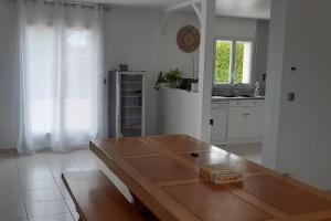 a kitchen with a wooden table in a room at Villa Folie Douce, accueille 10 pers avec Piscine in Réthôville