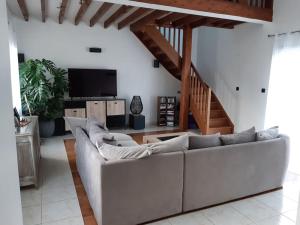 a living room with a white couch and a staircase at Villa Folie Douce, accueille 10 pers avec Piscine in Réthôville