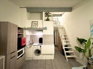 uma cozinha com máquina de lavar e secar roupa num quarto em Le repaire des voyageurs em Port Leucate