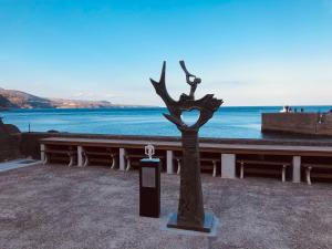 a statue of a tree in front of the water at Izu Hokkawa Seaside Guesthouse 伊豆北川の家 in Higashiizu