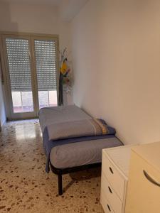 ein Schlafzimmer mit einem Bett, einer Kommode und einem Fenster in der Unterkunft Casa vacanze relax in Terrasini
