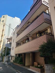 a brick building with a balcony on a street at ホテルサンクリスタ4階 in Tokyo
