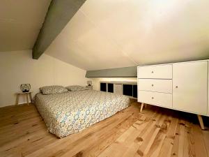 um quarto com uma cama e uma cómoda branca em Le repaire des voyageurs em Port Leucate