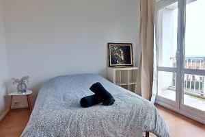 a bed with a black object on it in a bedroom at Paris / Disney 6 Personnes in Noisy-le-Grand