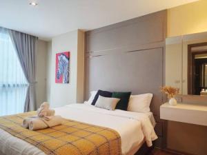 Un dormitorio con una cama con un osito de peluche encima. en AL Define Condo, en Bangkok 54 fotos más