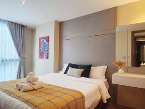 a bedroom with a bed with a teddy bear on it at AL Define Condo in Bangkok