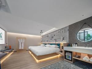 a bedroom with a large white bed and a mirror at Lanwan Hotel - Guangzhou Shamian Island Yongqingfang Branch in Guangzhou