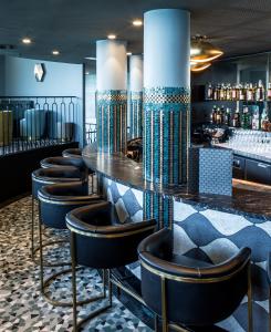 a bar with a row of stools in a room at Castelbrac Hotel & Spa in Dinard