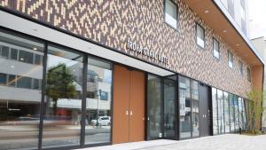 un magasin à l'avant d'un bâtiment avec des fenêtres en verre dans l'établissement Iroha Grand Hotel Matsumoto Eki-Mae, à Matsumoto