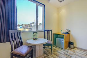 a room with a table and two chairs and a window at SMART PLAZA HOTEL-At Airport in New Delhi