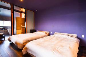 松山市にある由良民泊島宿の紫の壁のベッドルーム1室(ベッド2台付)