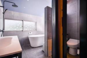 松山的住宿－由良民泊島宿，带浴缸、卫生间和盥洗盆的浴室