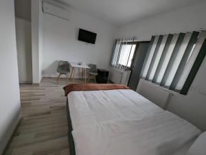 a bedroom with a bed and a table with chairs at 2Family in Focşani