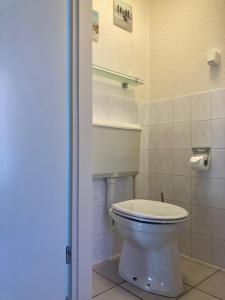 a bathroom with a white toilet in a room at Holiday House Platz an der Sonne for 6 people near Lake Lauwersmeer in Oostmahorn +43 photos