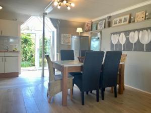 a dining room with a wooden table and chairs at Dijkrose in Oostmahorn +39 photos