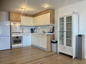 a kitchen with white appliances and wooden floors at Chalet Valentina directly on the Lauwersmeer in Anjum