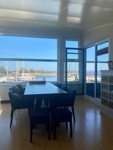 sala de estar con mesa y ventana grande en 6pers. Lauwersmeer Lakefront. Nirvana house with sauna, pellet stove en Anjum