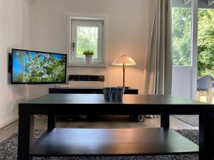 - un salon avec une table et une télévision dans l'établissement Olivia 6pers House with a private garden close to the National Park Lauwersmeer, à Anjum