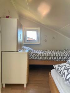 Dormitorio pequeño con cama y nevera en 6pers. Lauwersmeer Lakefront. Nirvana house with sauna, pellet stove en Anjum