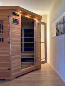 una sauna con puerta de cristal en una habitación en 6pers. Lauwersmeer Lakefront. Nirvana house with sauna, pellet stove en Anjum