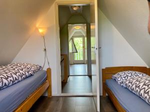 - 2 lits dans une chambre avec couloir dans l'établissement Olivia 6pers House with a private garden close to the National Park Lauwersmeer, à Anjum
