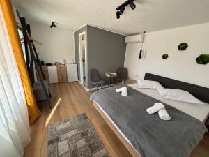 a bedroom with a bed with two towels on it at Tiny Houses Transfagarasan in Cîrţişoara