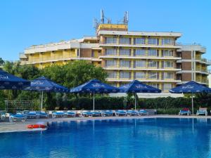 una piscina con sombrillas y sillas azules y un edificio en Hotel Orfeu, en Mamaia