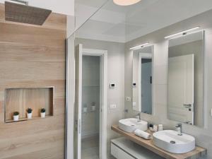 Baño con 2 lavabos y espejo en Villa Noga Rooms, en Selargius